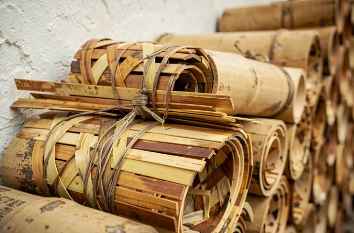 Gros plan sur des rouleaux de canisse en bambou empilés montrant la texture et le tressage naturel